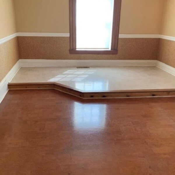 Harmony brown corrk flooring in a room with a white rasied platform and tan walls